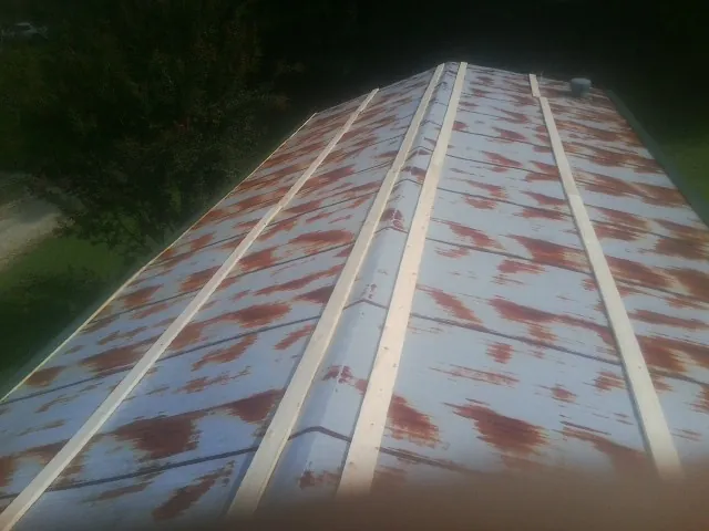 Rusted metal roof panels with new wood purlins before replacement — Storm Damage Roof Repair in Saint Ignatius by Roofing Brothers