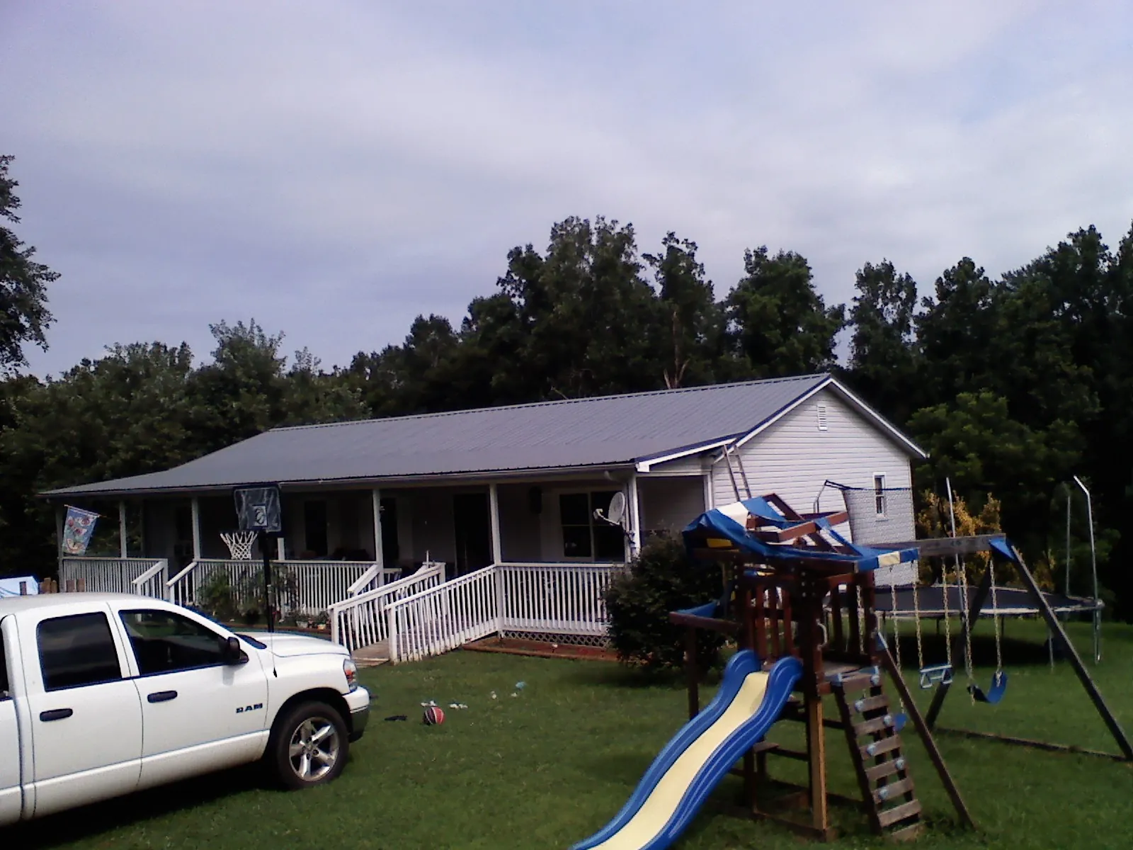 Dark metal roof on a country home with a full length front porch in Saint Ignatius