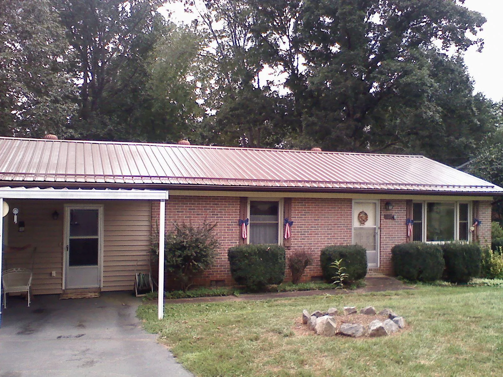 Bronze metal roof and carport on a brick ranch home — Roof Repair work by our crew in Saint Ignatius